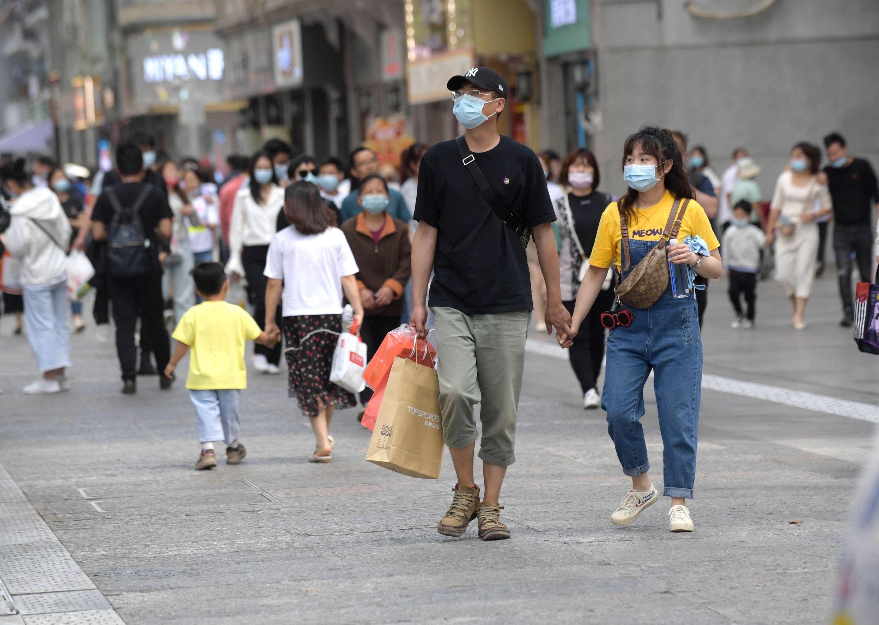 游人打卡江汉路步行街,拖着旅行箱逛不够