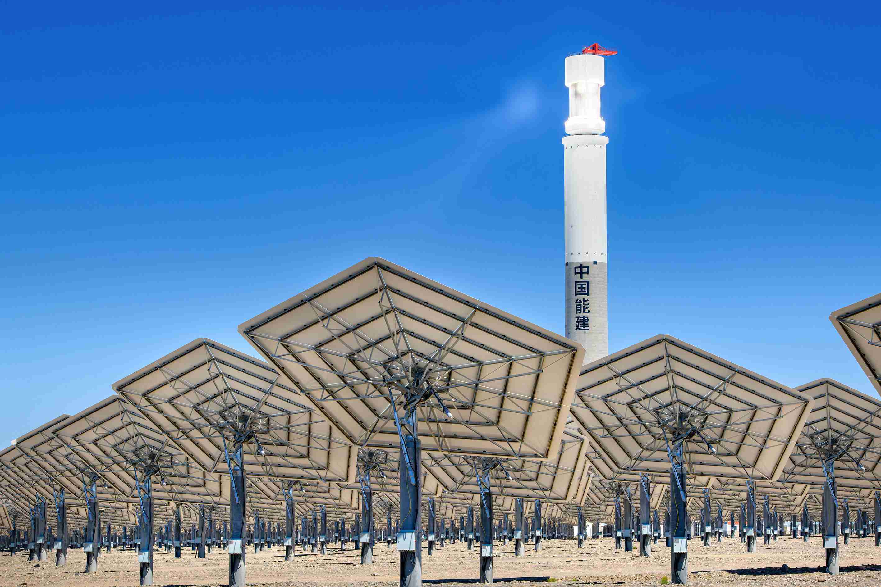 新疆哈密:50兆瓦熔盐塔式光热发电站调试定日镜 犹如一个巨大的银色