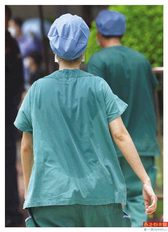 荔湾区骨伤科医院的医护人员换班下来,衣服后背出现汗渍轮廓.