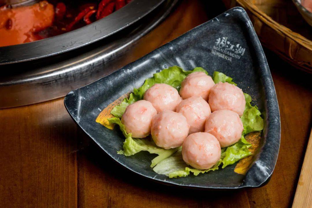 咸蛋黄爆浆虾丸在锅里涮烫片刻,微麻的牛舌裹挟着辣油入口,顿时舌尖像