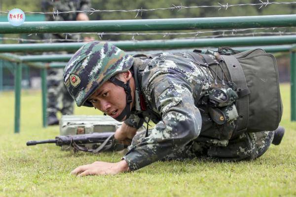 救护组合练习竞赛中,参赛官兵携弹药箱匍匐前进