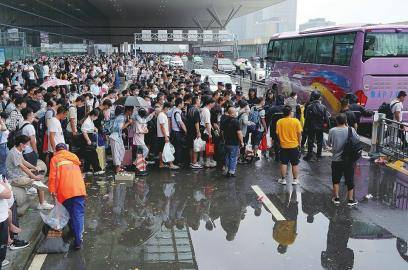 7月21日,滞留旅客在郑州东站进站口处排队登乘大巴车(新华社发)