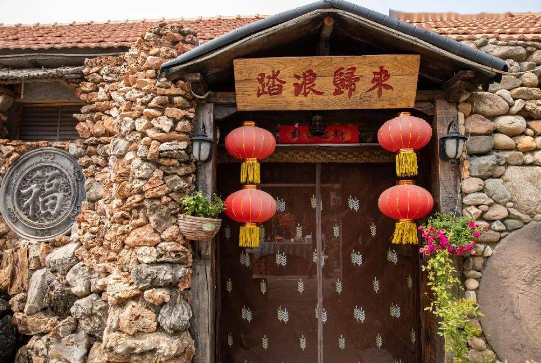 这是一处藏在院落里的民宿,沿着石拱门进去,能看到形态各异的花草