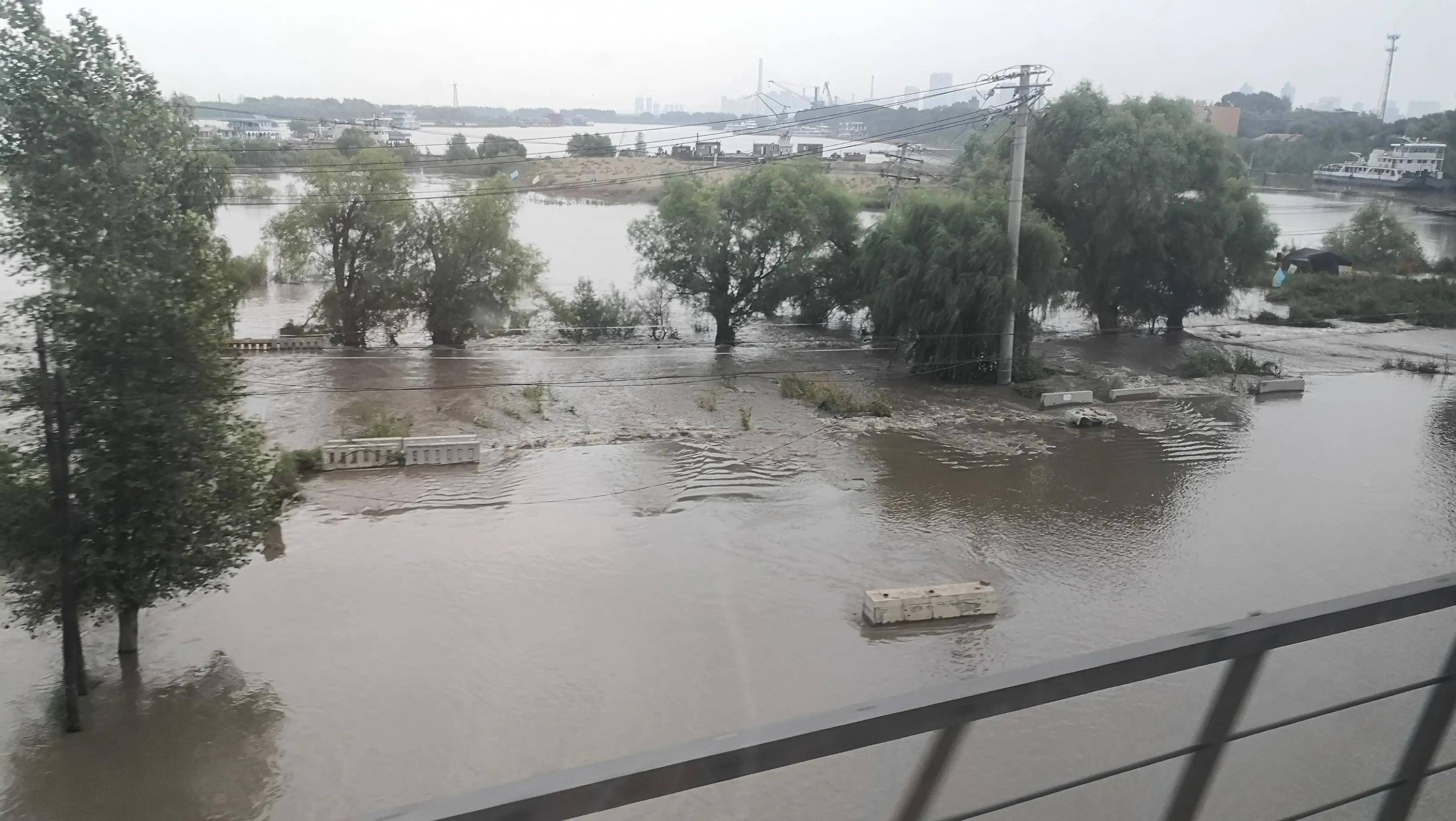 洪峰过境,哈市江北船厂社区通往外界的唯一车行通道被淹