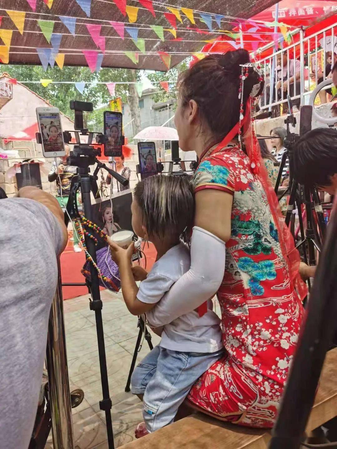 一名主播抱着另一位主播的孩子在直播"拉面哥".