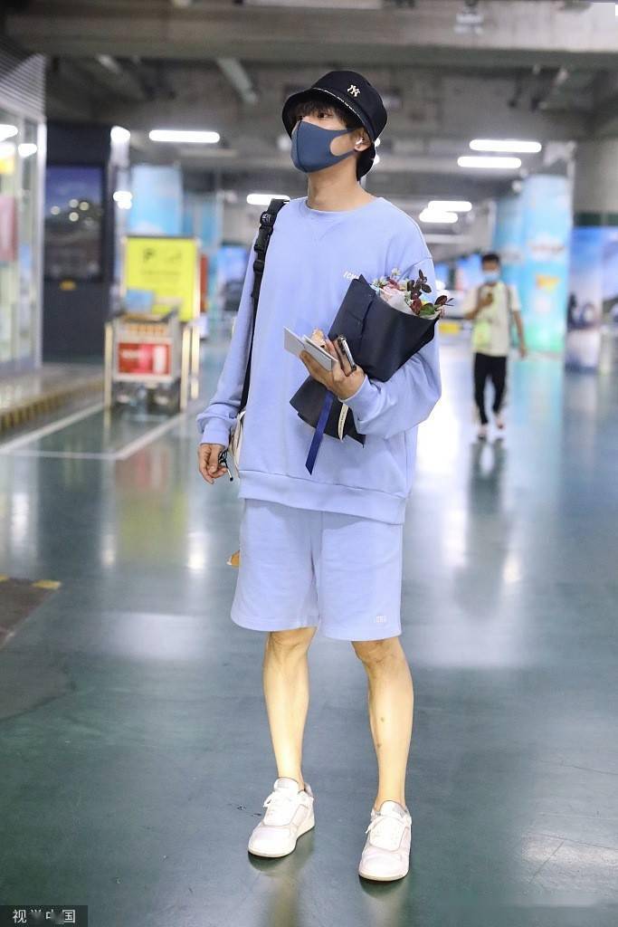 魏哲鸣蓝色卫衣套装清新活泼 戴渔夫帽抱粉丝送花乖巧_机场
