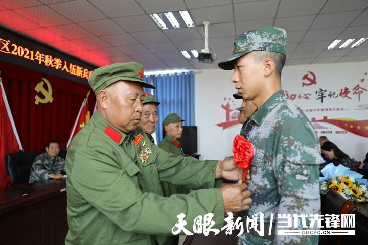 参战老兵为新兵佩戴红花