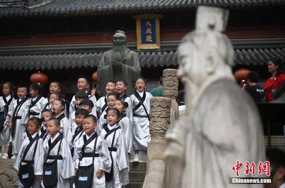 行古礼点朱砂"开笔破蒙",孩子们在南京夫子庙大成殿内的孔子像前留影