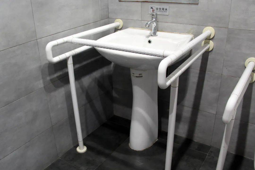 配有无障碍扶手设有无障碍卫生间,其中,坐便器和洗手池都配有无障碍