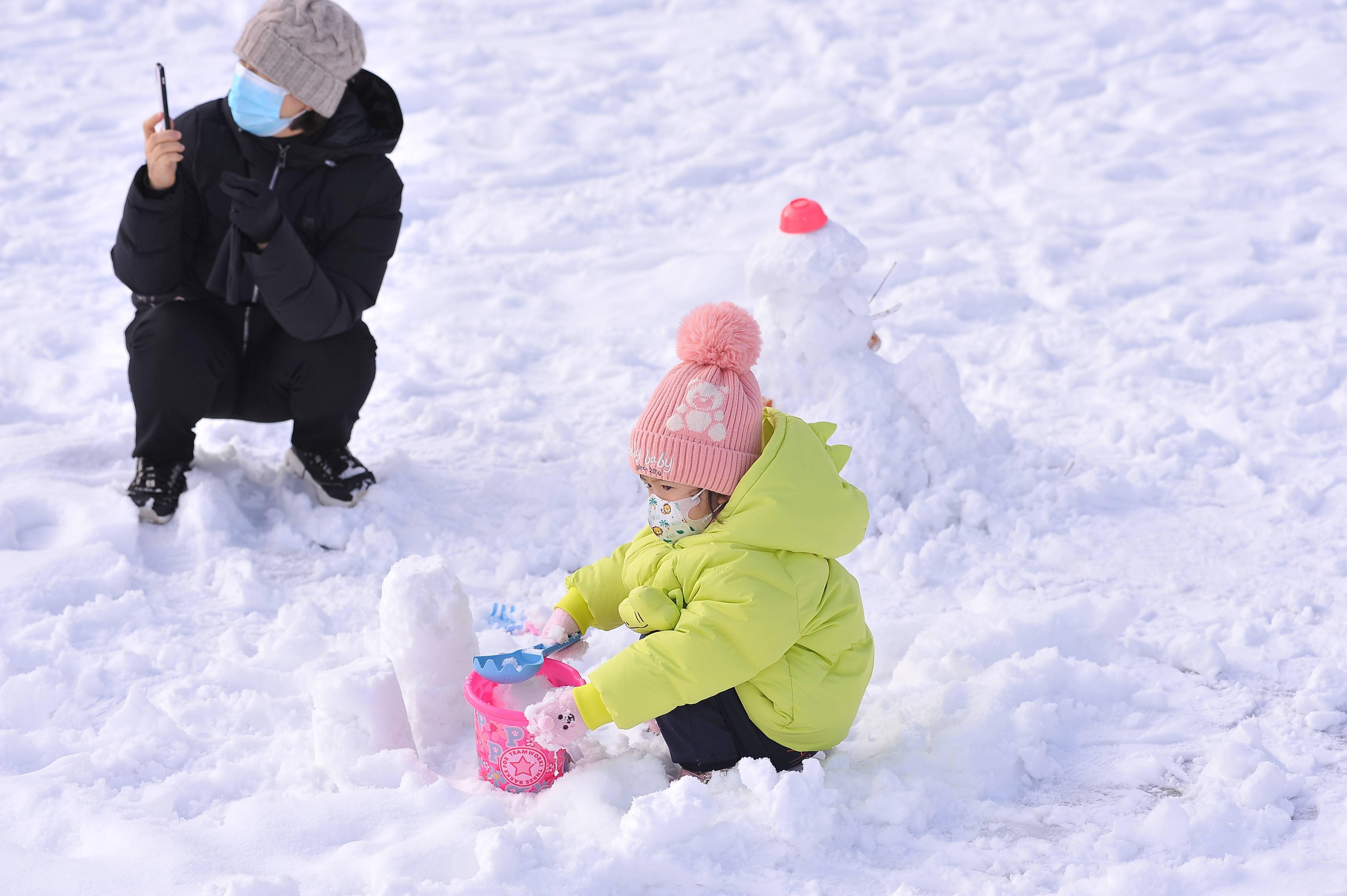 雪灾后,哈尔滨迎来了艳阳高照,家长带着孩子玩雪
