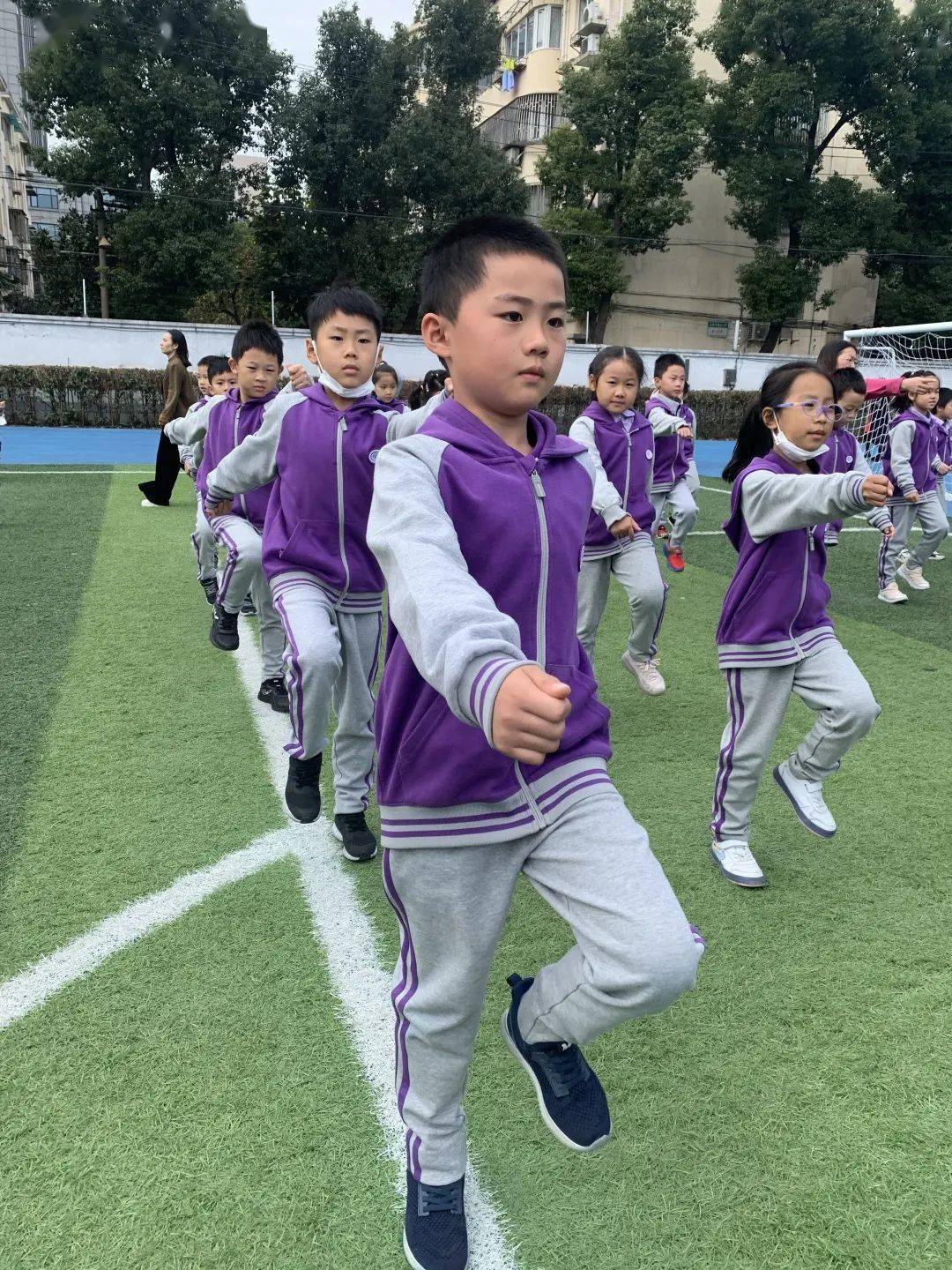 早操后在体育老师的带领下福娃们在绿茵场上进行简单的跑跳活