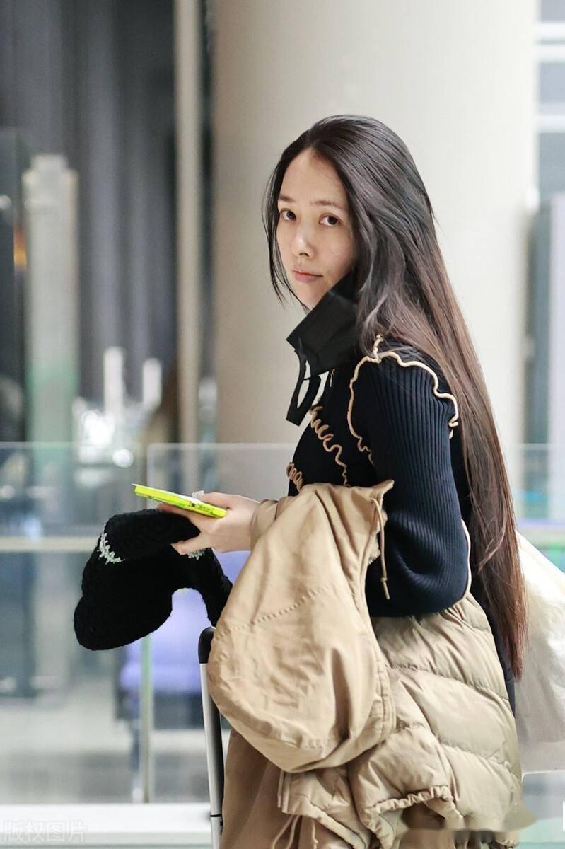 街拍:郭碧婷黑色针织衫 工装裤 短靴 钩针帽温婉甜美_机场