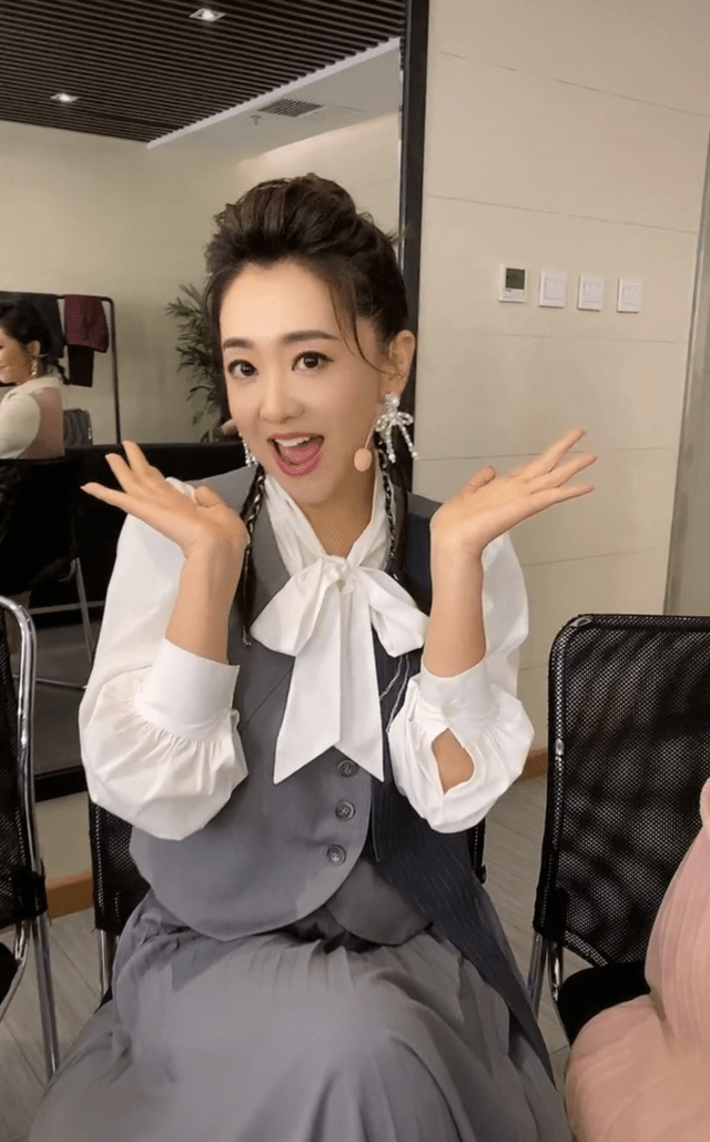 "童年女神"月亮姐姐坐在方琼的身旁,她身穿灰色裙子,和方琼一样内搭