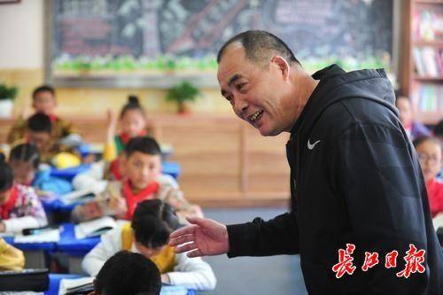 在学生自由朗读时,刘文全则在班上来回走动,俯身弯