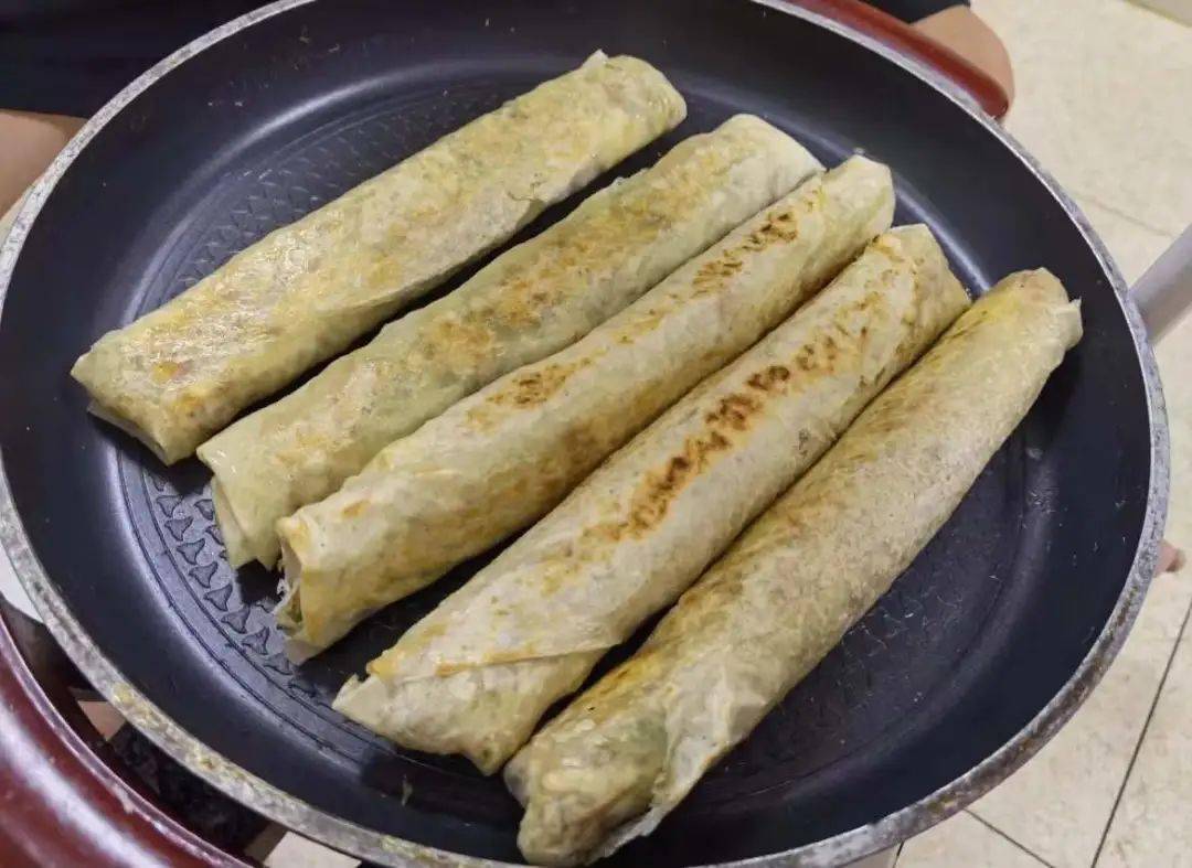 包饺饼筒可是一个难度活,先把各种材料平铺在饼皮上,再卷起来成条状