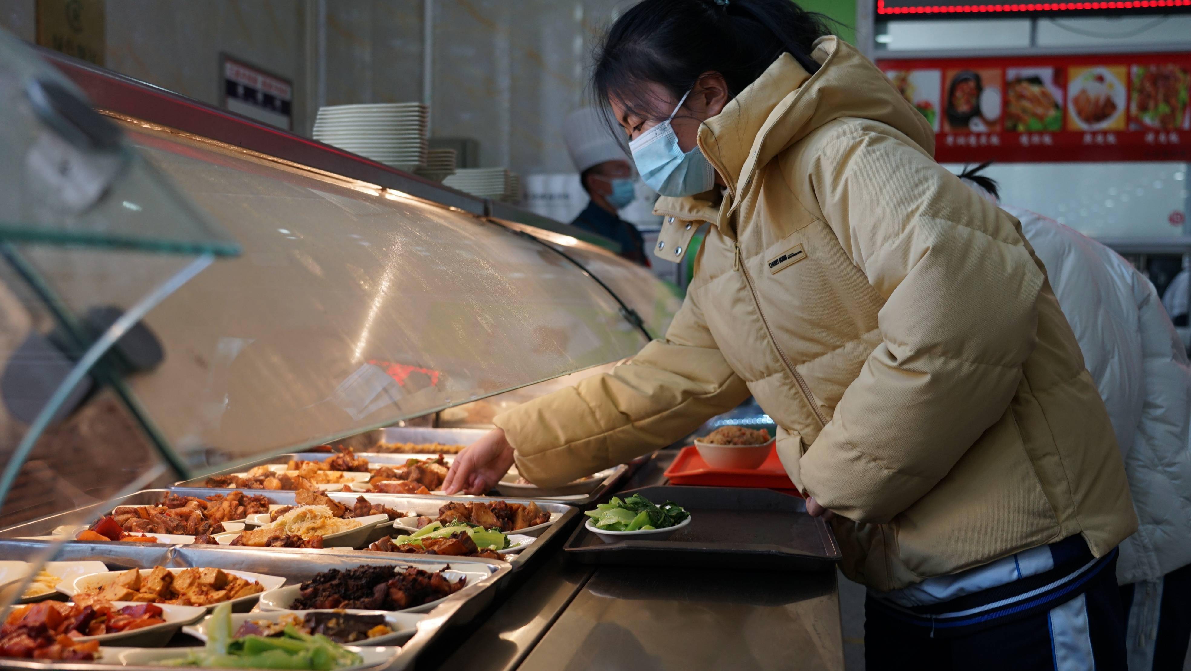 观察在青海省西宁市第五高级中学食堂,学生在挑选小碗菜(1月6日摄)