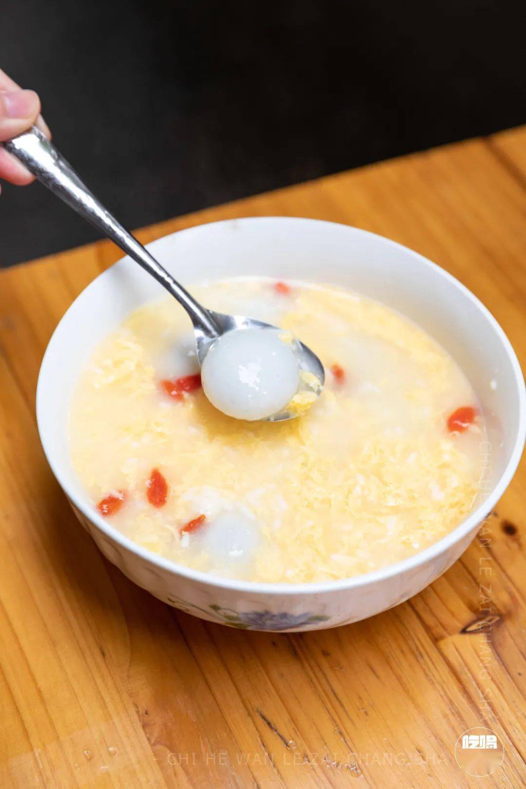 甜酒冲蛋里埋藏着汤圆,糯米和蛋花,配上几粒枸杞点缀着,充满酒香又