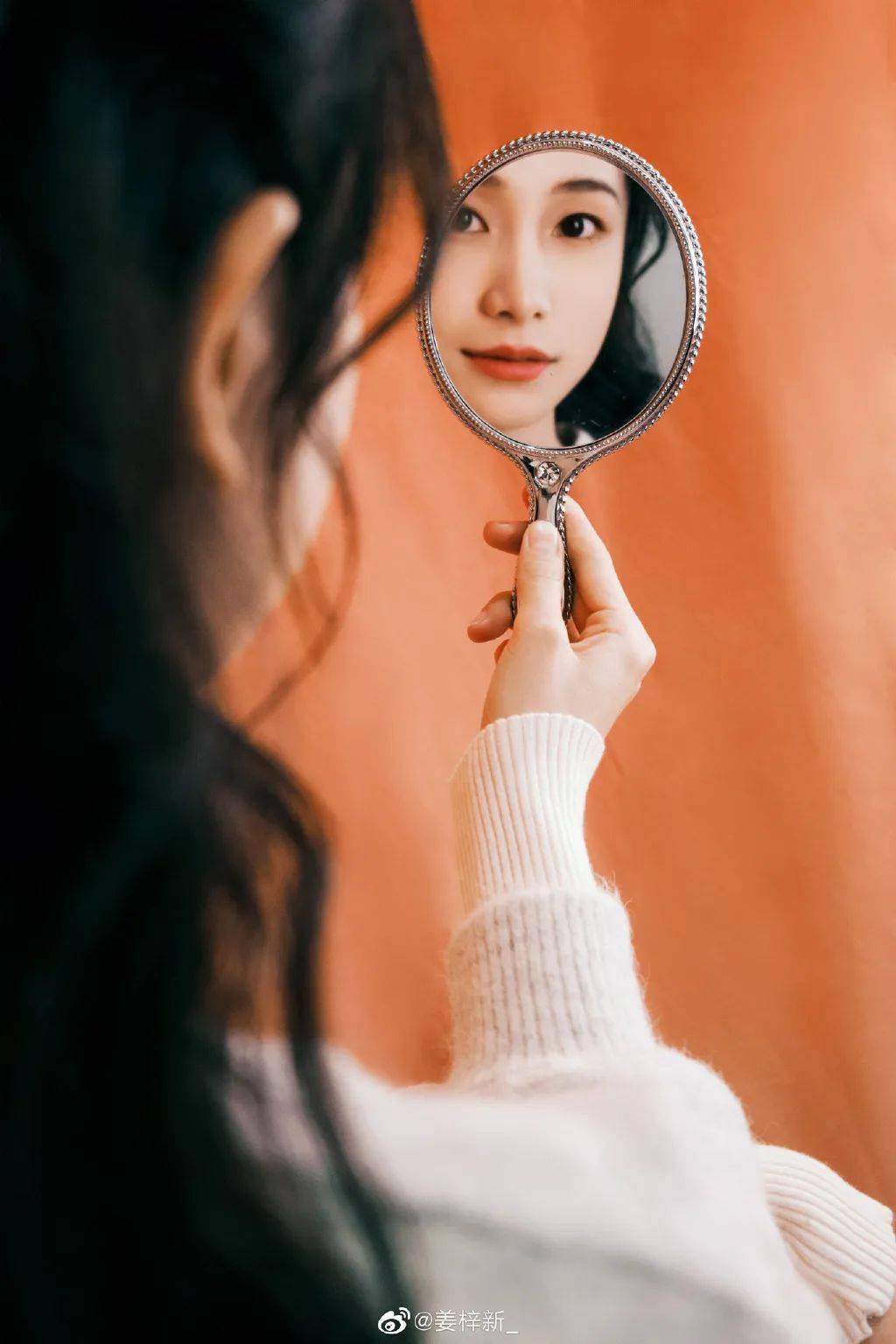 姜梓新的米白色针织外套搭配烟粉色丝绒材质的半身长裙,瞧上去十分