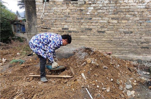 李芝平正在清理场地内堆积的泥土据了解,沙厂街道在当初建设时并未