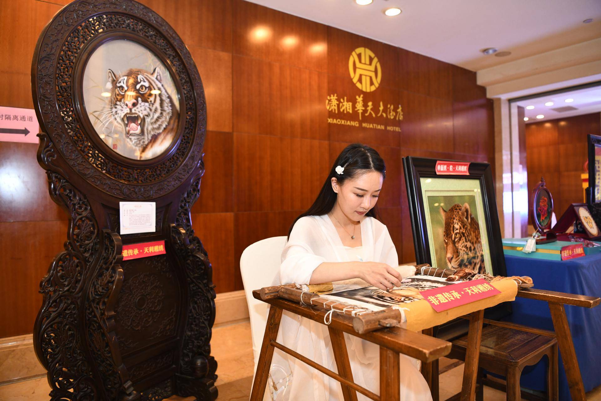 "在湖南沙坪天利湘绣现场刺绣表演台前,一位观众对绣女小姐姐的技艺赞