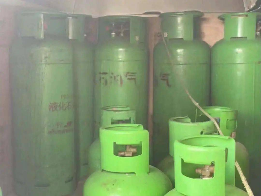 胆真大超市边竟然堆积了几十瓶煤气罐还有人抽着烟经过