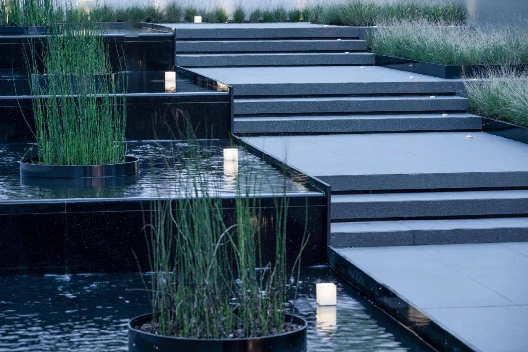 借助台阶高差的变化,在步梯两边设跌水景观,润泽的水流柔化了现代材料