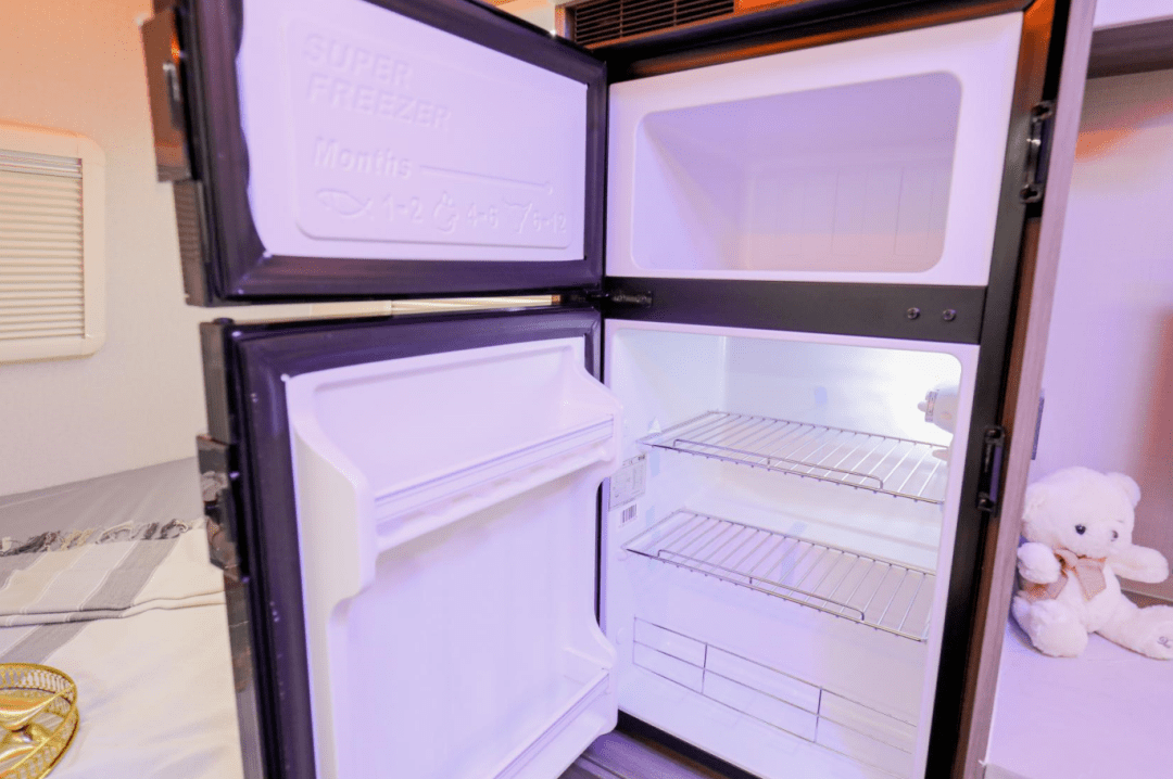 多功能区域的旁侧立柜里内嵌有一台118l房车专用冰箱,帮助车友储存