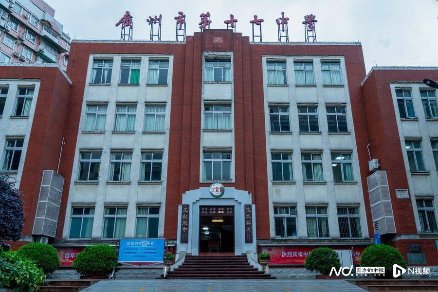 广州市第十七中学,教学楼门口有疫情防控相关提示的展板.