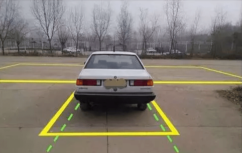 当车头引擎盖刚好盖住库对面边线时,向左打死方向盘.