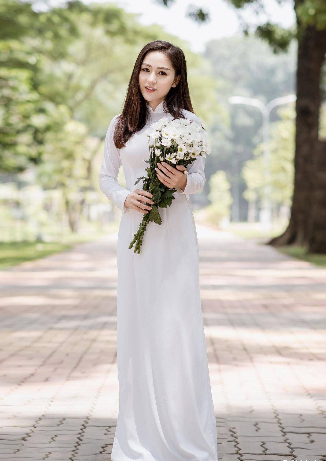 手捧鲜花,身穿白色奥黛,气质温婉,笑容阳光的国外姑娘真美_一笑_美女