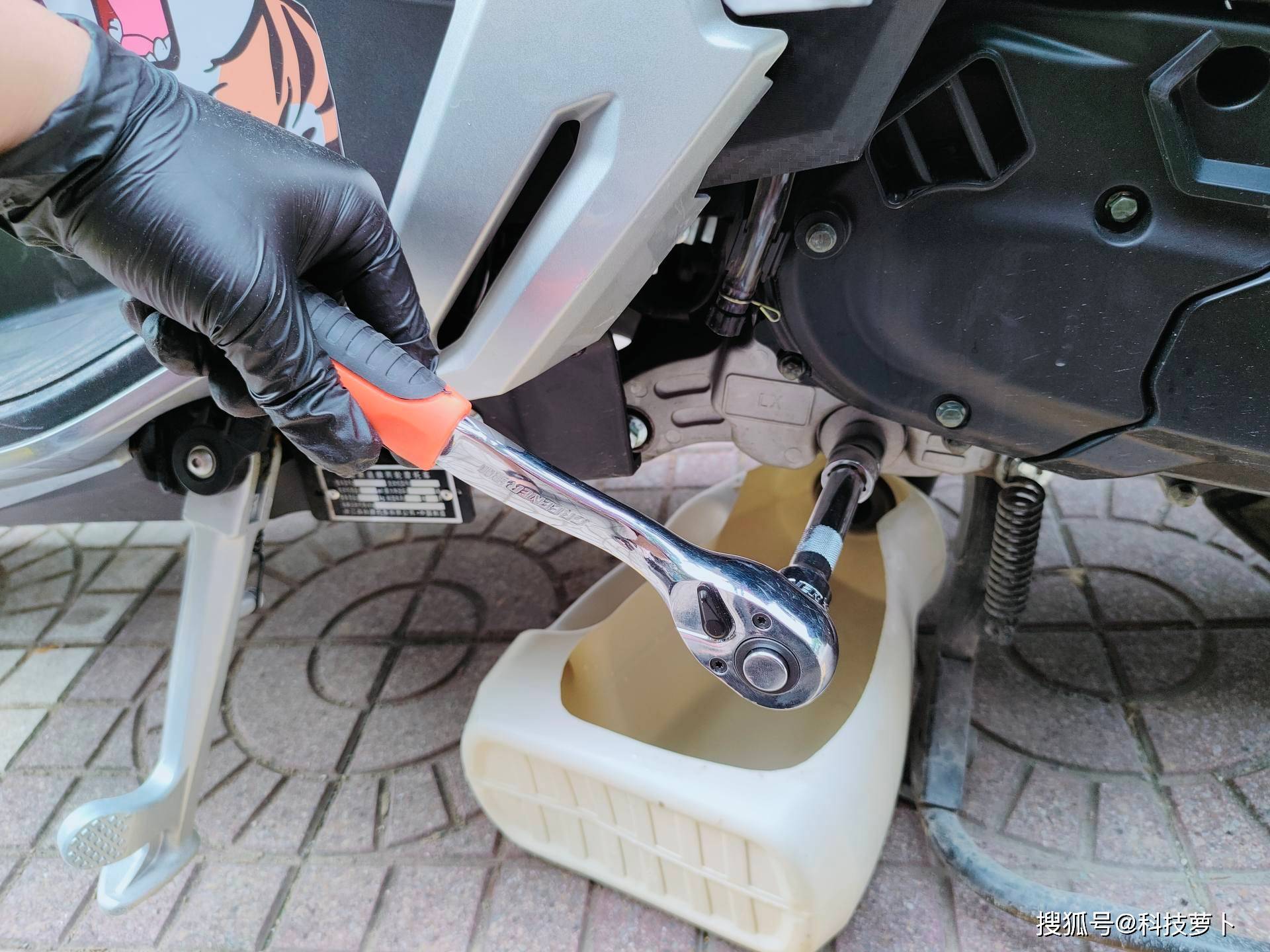 螺丝松开后,流出了黑色的机油,大家可以看到150cc及以下水冷踏板摩托