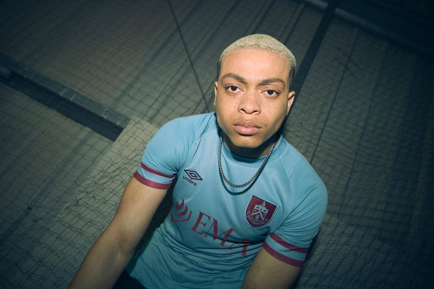 球衣上的队徽,umbro logo以及胸前广告均以深紫红色呈现.