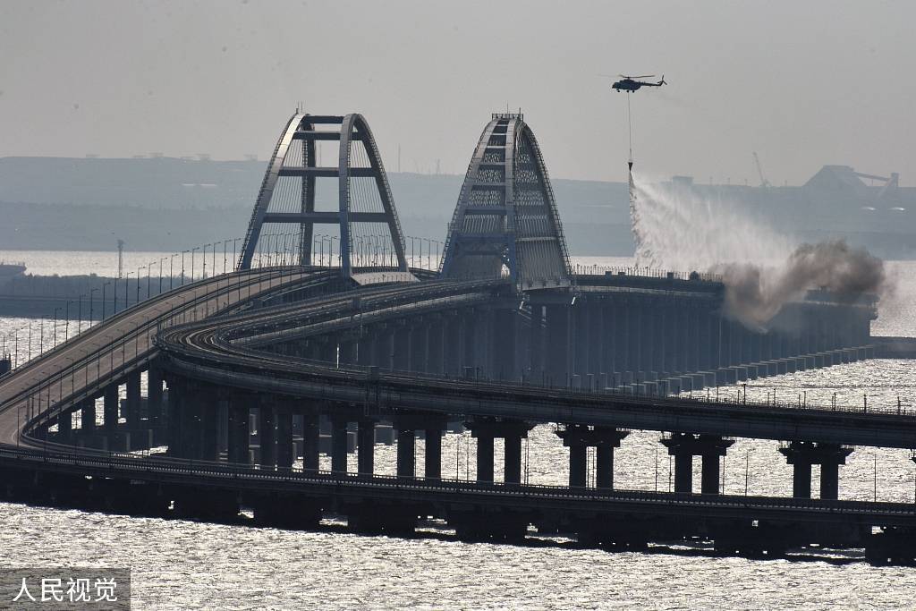 一架直升机在连接俄罗斯大陆和克里米亚半岛的刻赤海峡大桥上洒水灭火