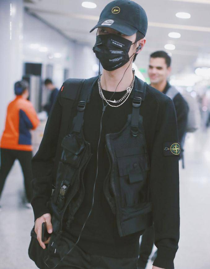 是王一博在机场的图片,他身穿黑色的卫衣,并且外面还有一件工装马甲