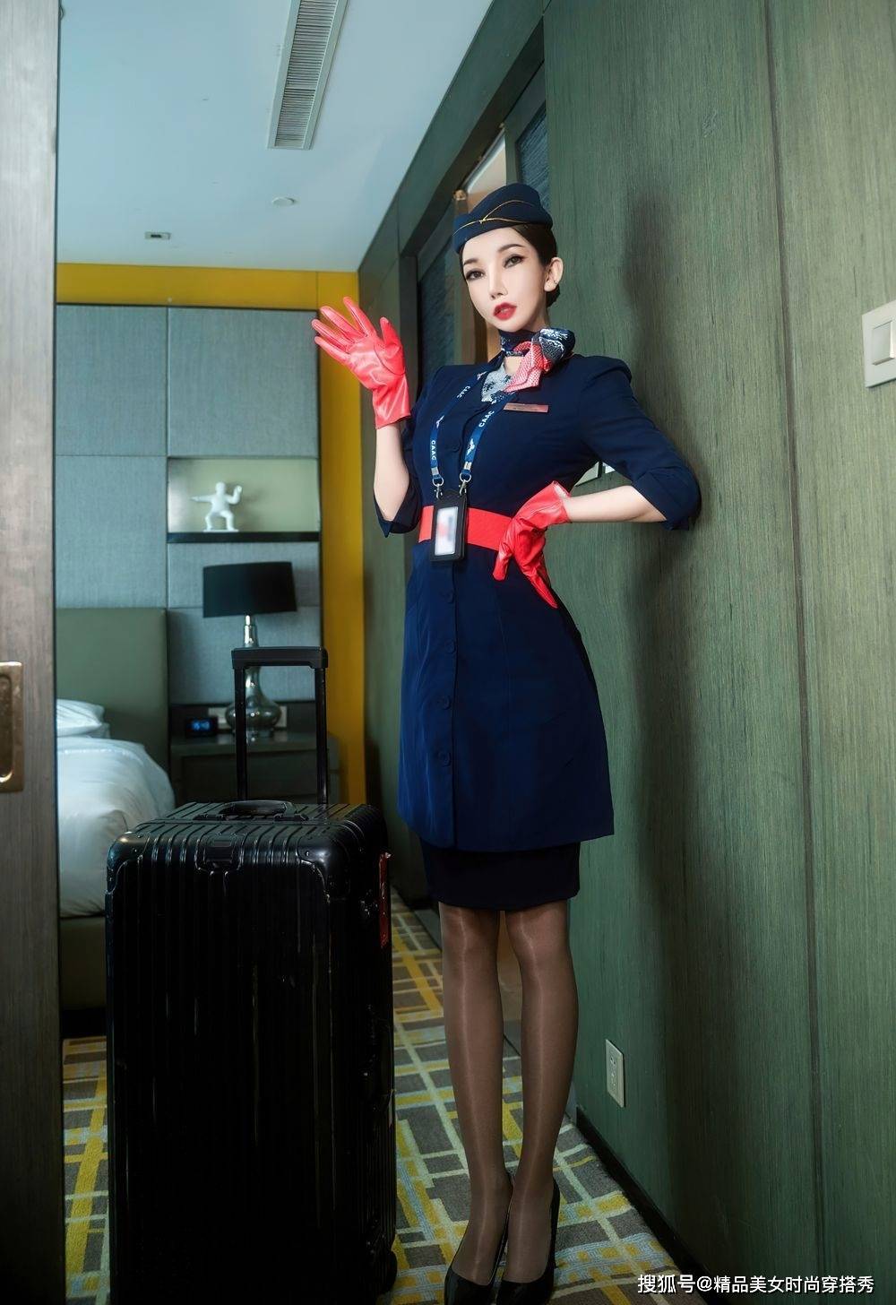 藏蓝色空姐制服套装搭配红色腰带和藏蓝色漆皮细跟高跟鞋干练有范