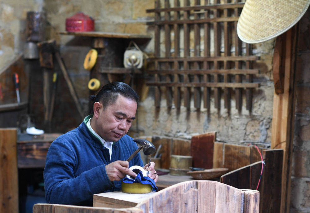 打小跟着父辈学习银饰锻造的王国春,长大后以银饰为