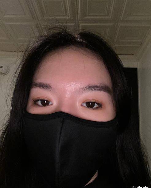 画面中,法图麦戴着黑色口罩,几乎将半张脸遮住,头发随意散落在肩头