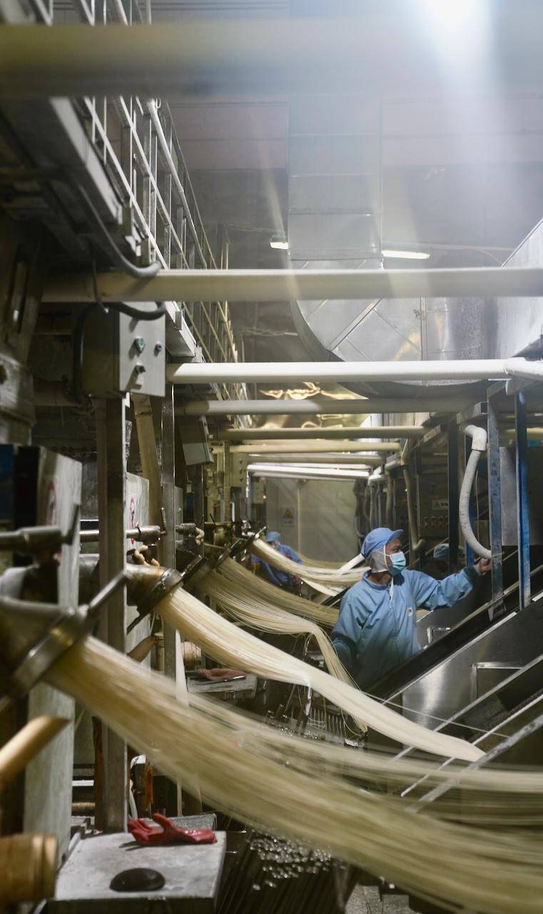 1月10日,会昌县五丰食品有限公司的工作人员在车间进行挤丝工序.