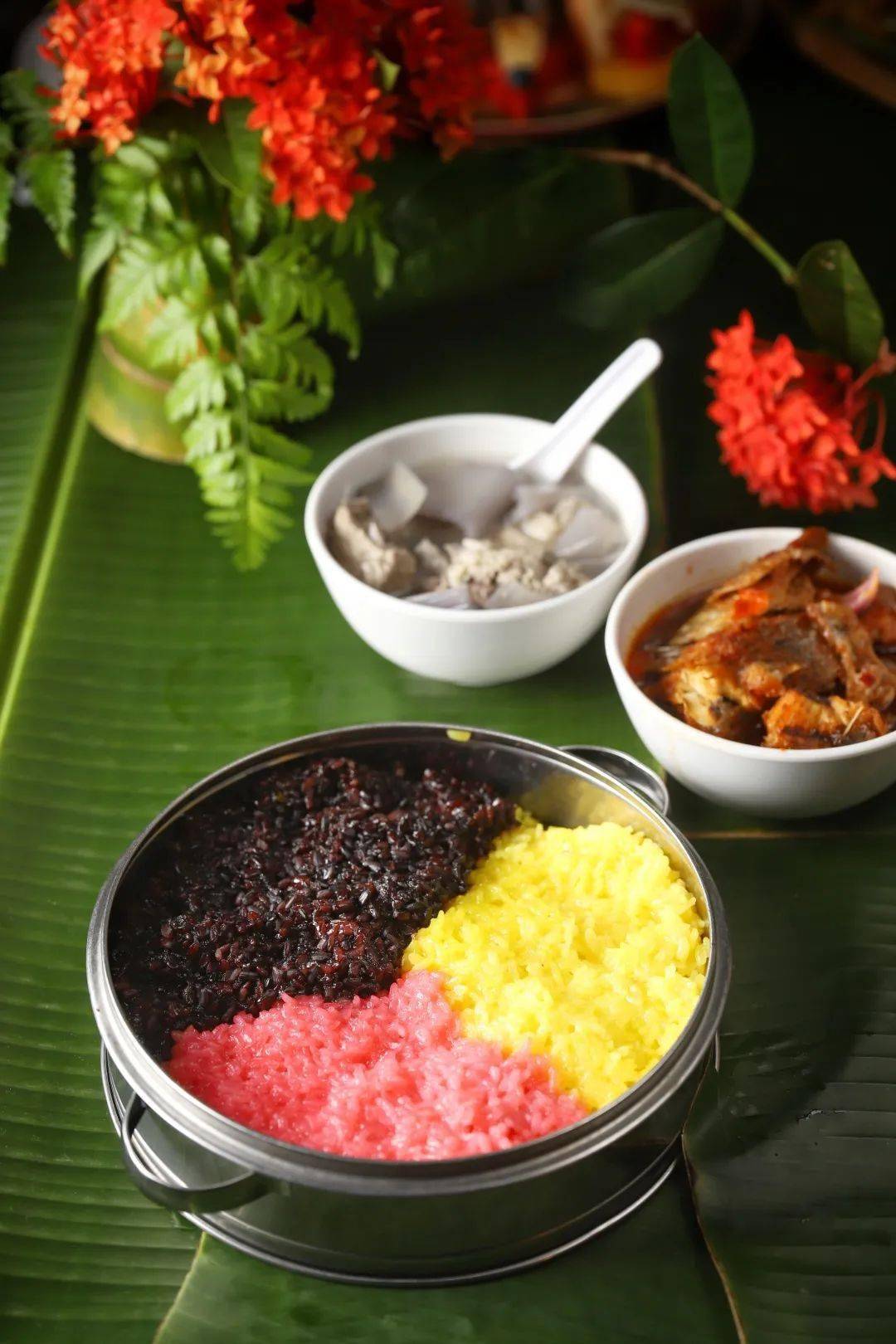 三色饭有红,黄,黑三色,分别取色于新鲜植物红蓝藤,黄姜和三角枫汁液