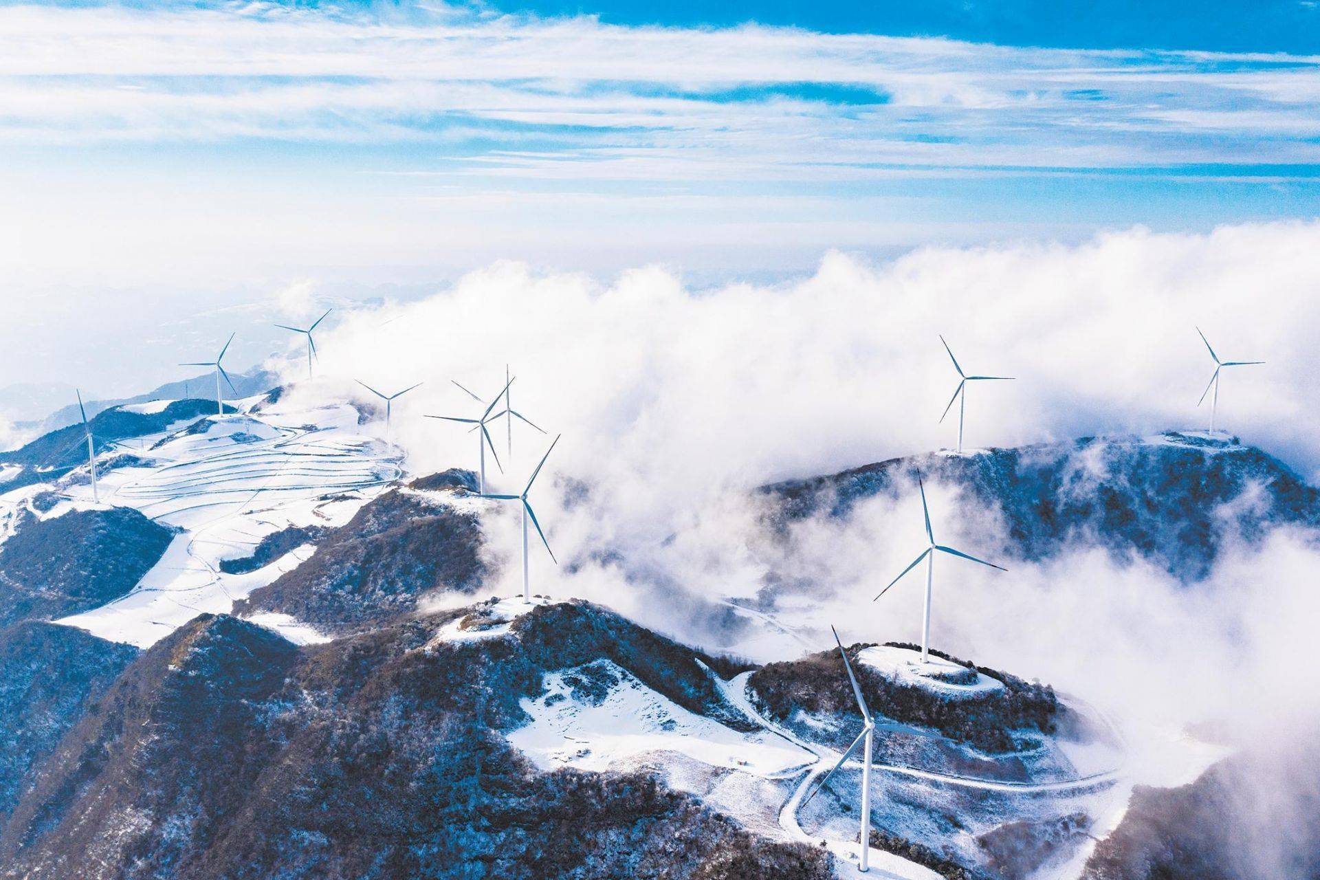 市秭归县云台荒风力发电场银装素裹,风电机组在云海中旋转,美景如画