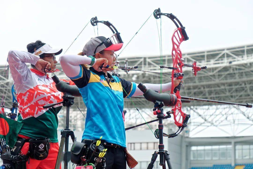 比赛场地内,参赛各国国旗迎风招展,选手们一字排开,屏气凝神,开弓张弦