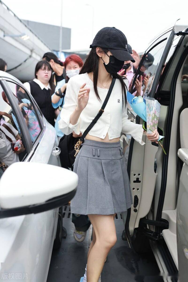 周也落地上海虹桥机场,无领针织衫搭配a子裙时尚洒脱