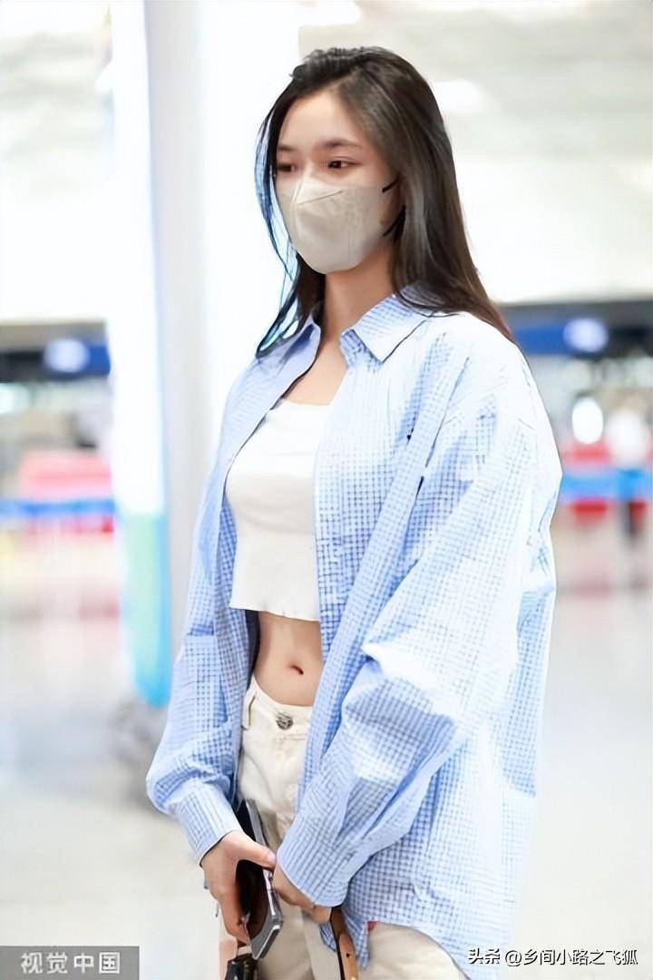 林允北京首都机场出发,蓝色衬衫搭配印花白色长裤洞洞鞋轻快可爱