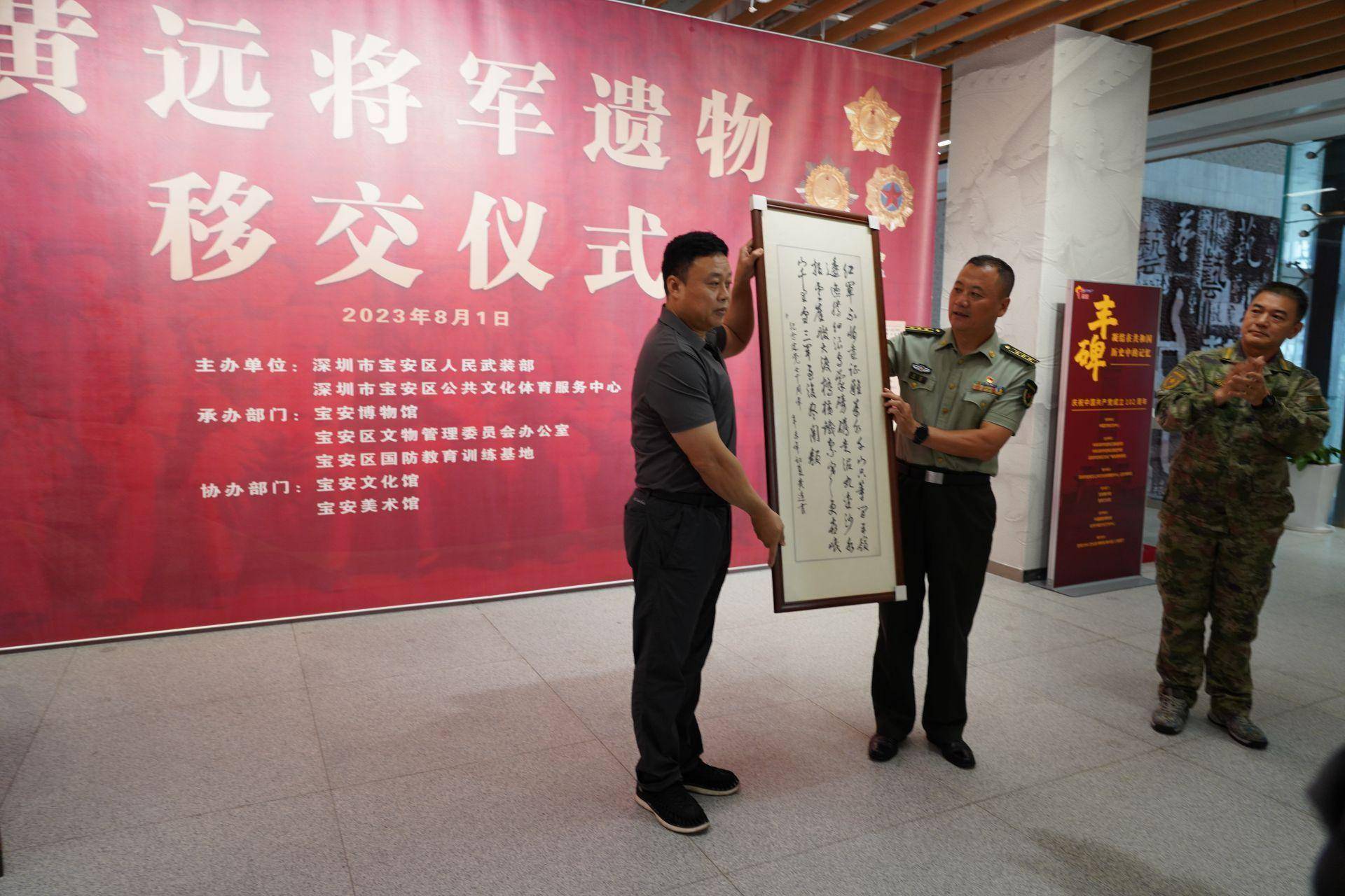 正在移交的是黄远将军的书法作品.
