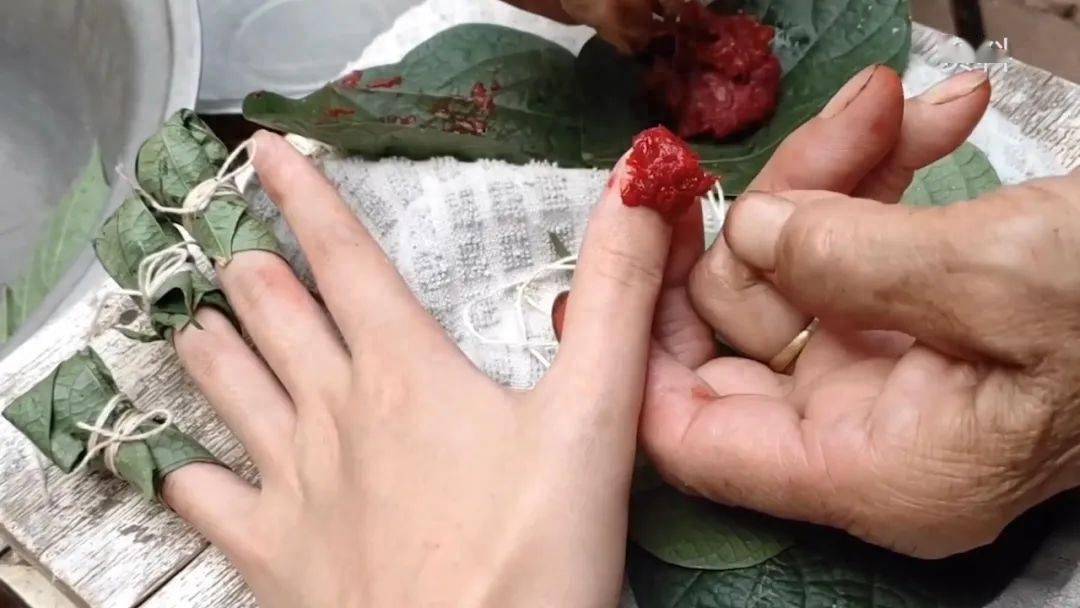 女子使用凤仙花花瓣染指甲.