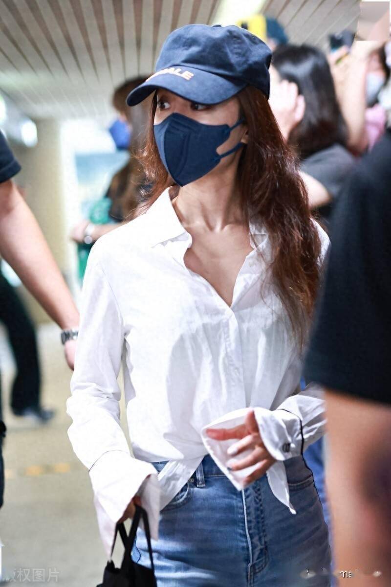 蔡依林白衬衫 牛仔裤 运动鞋 棒球帽 黑色手提包简单时尚_上海_机场