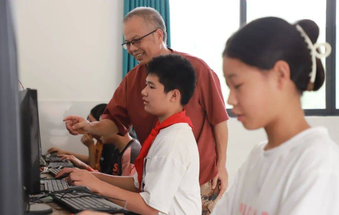 在学校的电脑室,欧新发鼓励六年级的学生比赛打字.