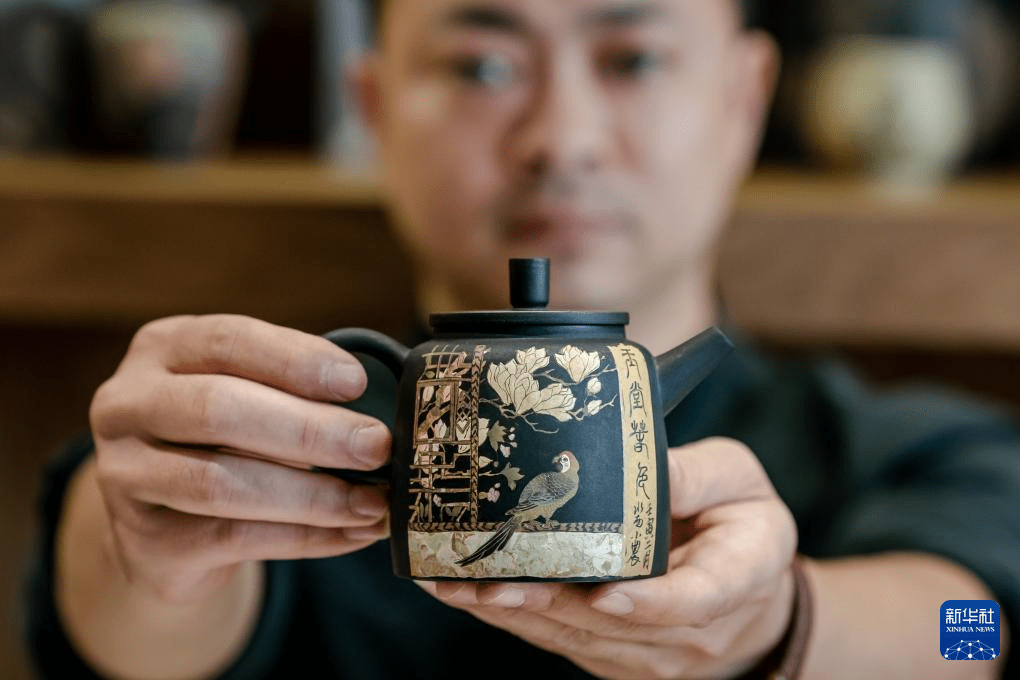 2022年6月30日,建水县紫陶艺人在工作室内展示制作的紫陶茶壶.