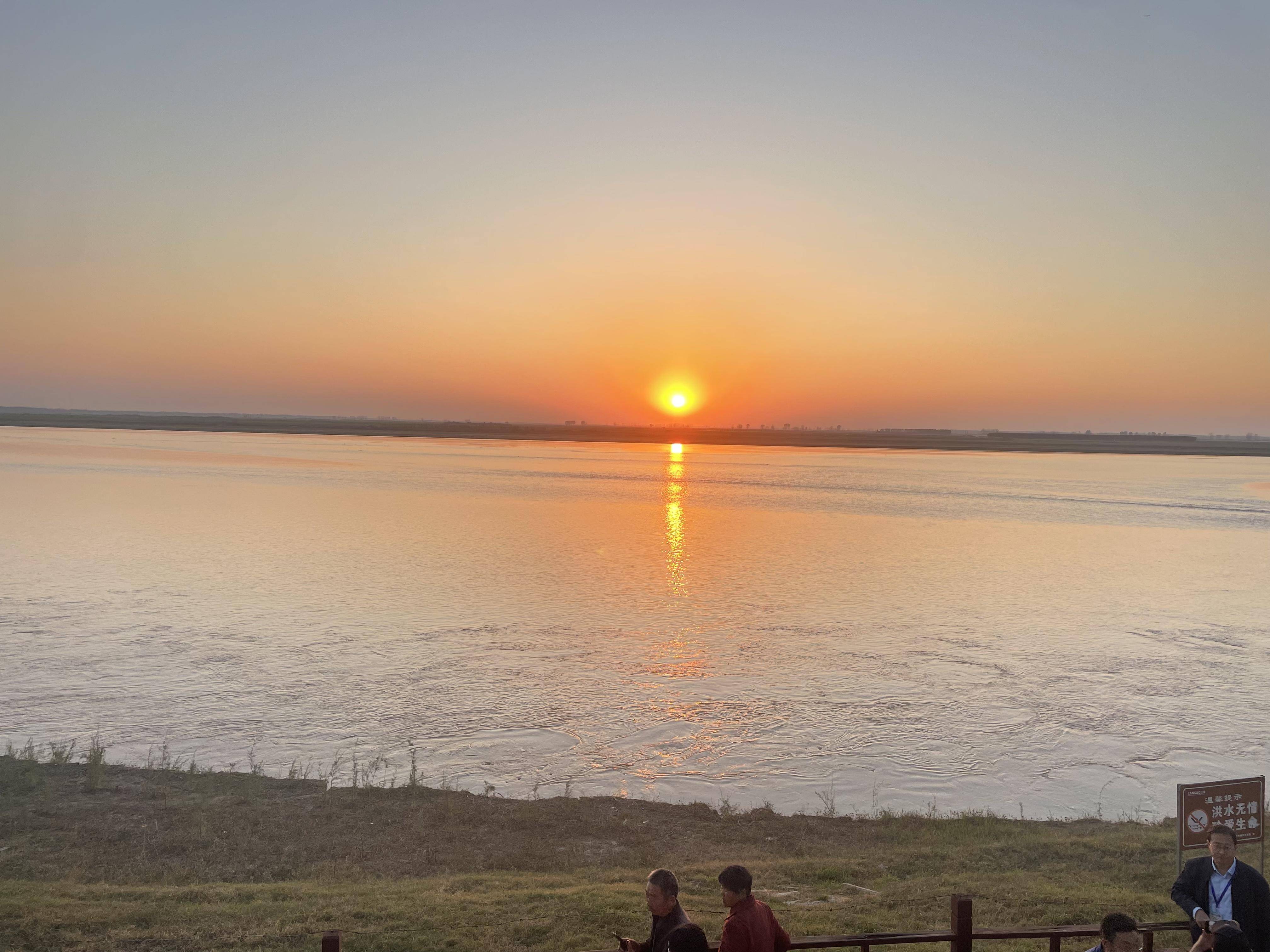 黄昏时分,驻足兰考县东坝头镇黄河滩边,夕阳染红了黄河水,静水深流